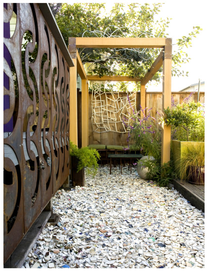 Backyard arbor from recycled products, tumbled dish pathway mulch in Matthew Levesque small space backyard california garden